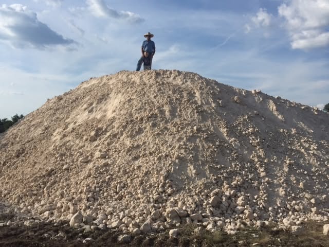 Person standing on top of a large crushed rock pile at a Bar Spur Co job site